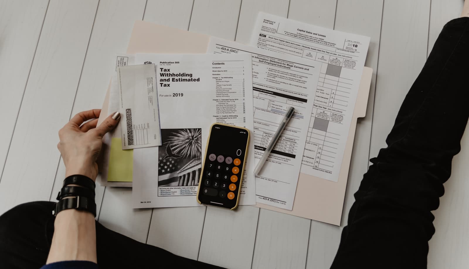 Bureau d'artisan avec calculatrice, factures et ordinateur portable préparant la facturation électronique 2026